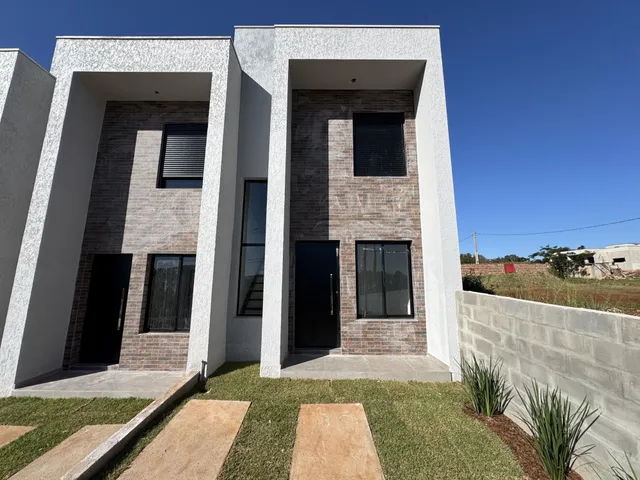 Fachada de uma residência moderna com revestimento de tijolos aparentes e detalhes em branco.