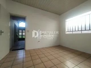 Ambiente interno de uma sala com piso de cerâmica e janela.