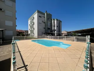Vista externa de uma piscina e área pavimentada de uma residência em Lajeado.