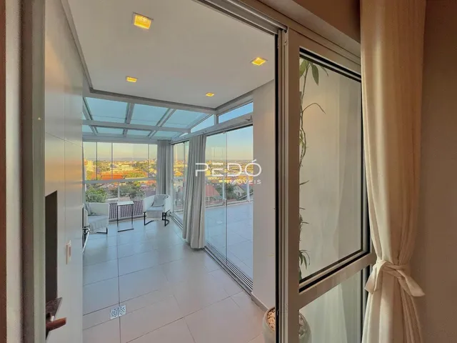 Sala de estar com vista para o exterior através de grandes portas de vidro.