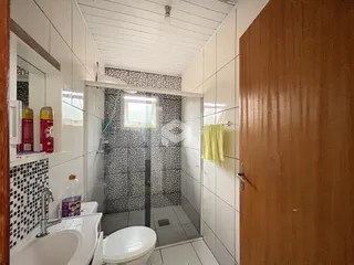 Foto de um banheiro com azulejos brancos e cinzas.
