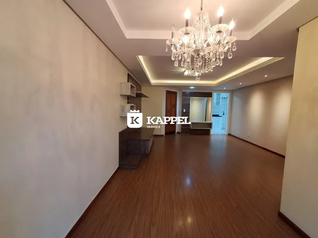 Sala de estar com piso de madeira e lustre de cristal.