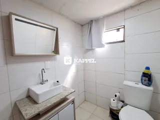Foto interna de um banheiro com pia e vaso sanitário.