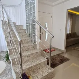 Foto de uma escadaria com corrimão de metal em um ambiente interno.