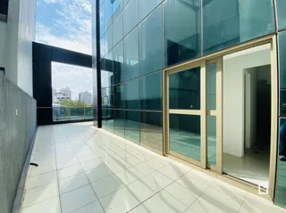 Vista de um corredor interno com piso de cerâmica e paredes de vidro.