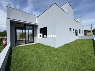 Fachada de uma casa moderna branca com gramado verde.