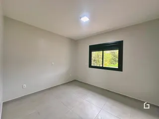 Ambiente interno de uma sala com paredes brancas e piso de cerâmica.