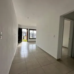 Corredor interno com piso de cerâmica e paredes brancas.