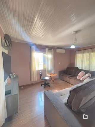 Sala de estar com sofá e piso de madeira clara.