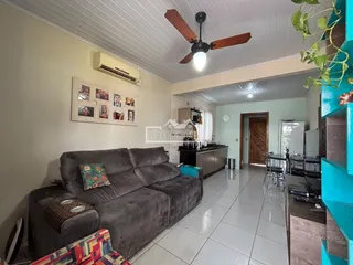 Sala de estar com sofá e piso de cerâmica em um imóvel no Brasil.