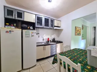 Foto de uma cozinha com armários brancos e eletrodomésticos.