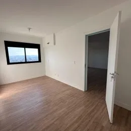 Foto de um ambiente interno com piso de madeira e uma janela.