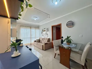Sala de estar com piso de porcelanato claro e grandes janelas.
