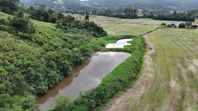 Vista panorâmica de uma paisagem rural com rio e vegetação densa.