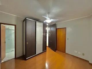Corredor interno com piso de madeira e portas de madeira escura.