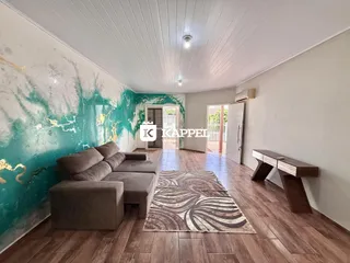 Esta é uma sala de estar com sofá grande e piso de madeira em uma residência.