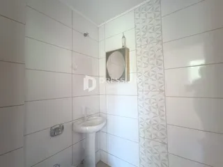 Um banheiro com revestimento de azulejos brancos e detalhes geométricos na parede.