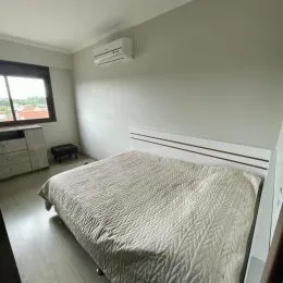 Quarto com cama e aparelho de ar-condicionado instalado na parede.