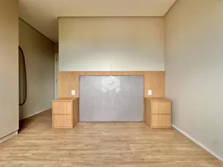 Um corredor com piso de madeira e painel central na sala.