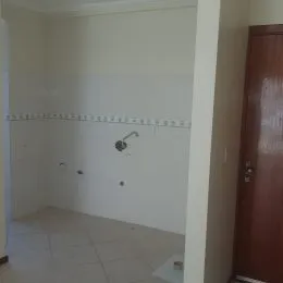 Foto de um cômodo interno com paredes brancas e piso de cerâmica.