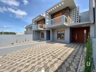 Fachada de uma residência moderna em Lajeado, Brasil, com terraço e área pavimentada.