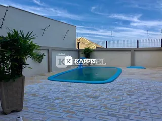 Foto de uma área externa com uma piscina e piso de ladrilhos.