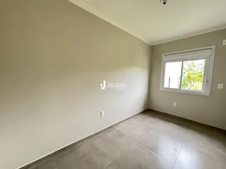 Vista interna de uma sala com piso de cerâmica e parede clara.