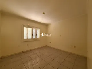 Foto interna de uma sala com piso de cerâmica e janela.