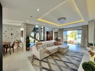 Sala de estar moderna com sofá e piso claro em um imóvel no Brasil.