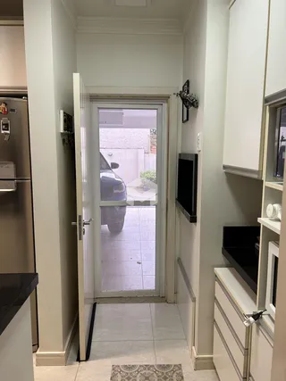 Hall de entrada com porta de vidro que dá para o exterior.