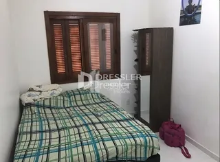Quarto com cama e armário de madeira no interior da propriedade.