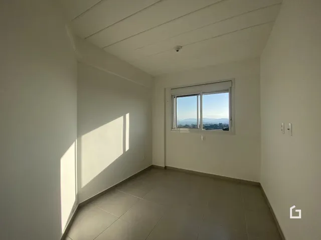 Interior de um cômodo com piso de cerâmica e janela.