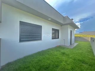 Fachada de uma residência branca com gramado verde.