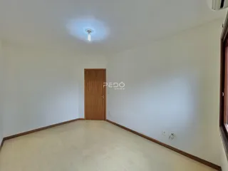 Hall de entrada com piso de madeira e porta de madeira.