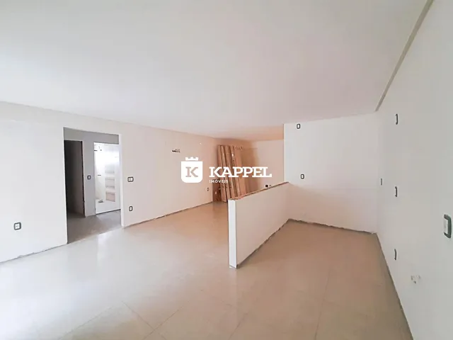 Hall de entrada com paredes brancas e piso claro.
