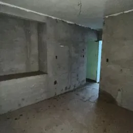 Vista interna de um corredor com paredes de concreto aparente.