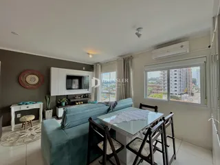 Sala de estar com sofá e mesa de jantar em um apartamento no Brasil.