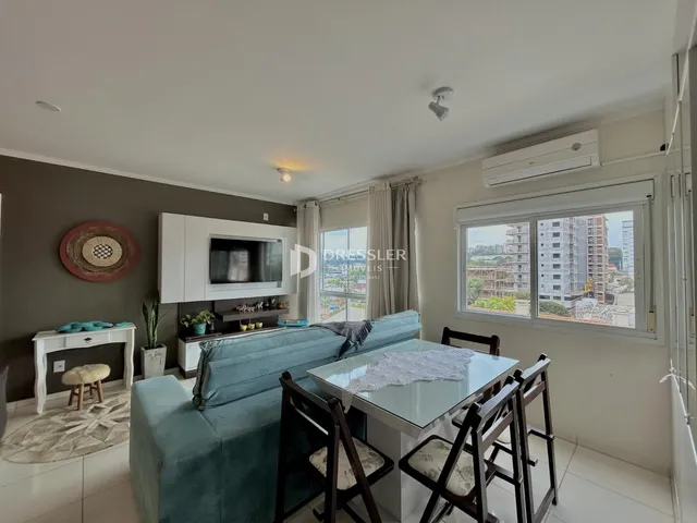Sala de estar com sofá e mesa de jantar em um apartamento no Brasil.