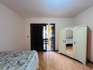 Quarto com cama e armário de madeira na sala.