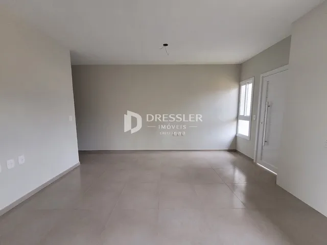 Vista interna de um ambiente com paredes brancas e piso claro.