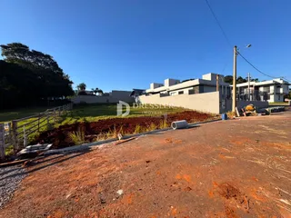 Vista externa de uma propriedade com cerca e terreno em terra.