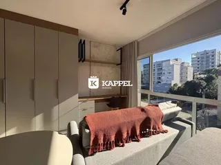 Sala de estar com sofá e vista para o exterior.