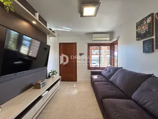 Sala de estar com sofá e televisão em um imóvel no Brasil.