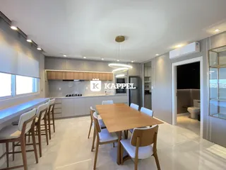 Sala de jantar com mesa de madeira e armários modernos em um apartamento.