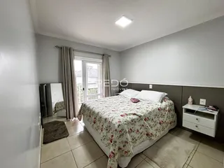 Quarto com cama e porta de vidro na janela.
