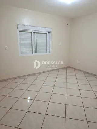 Vista interna de um cômodo com piso de cerâmica e janela.