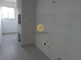 Hall de entrada com piso claro e parede revestida de azulejos brancos.