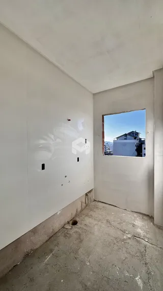 Foto de um cômodo com paredes brancas e piso de concreto.