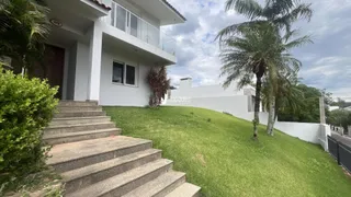 Fachada de uma casa branca com jardim gramado e escadaria.
