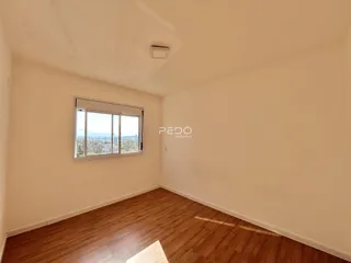 Ambiente interno com piso de madeira e janela.